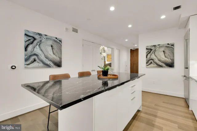 a kitchen with stainless steel appliances granite countertop a sink and a refrigerator