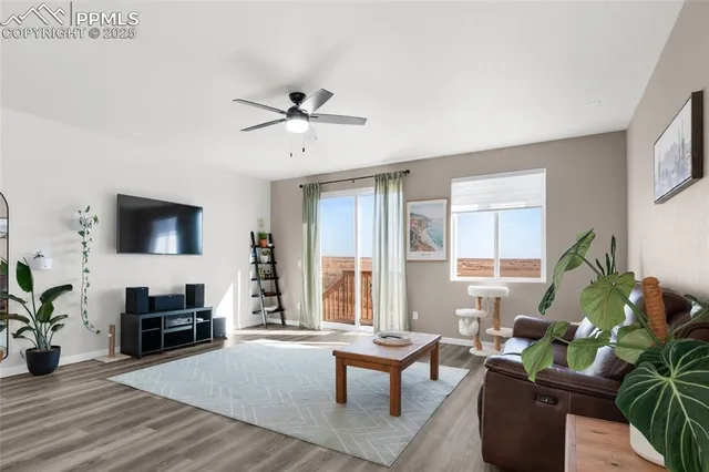 a living room with furniture a flat screen tv and a window