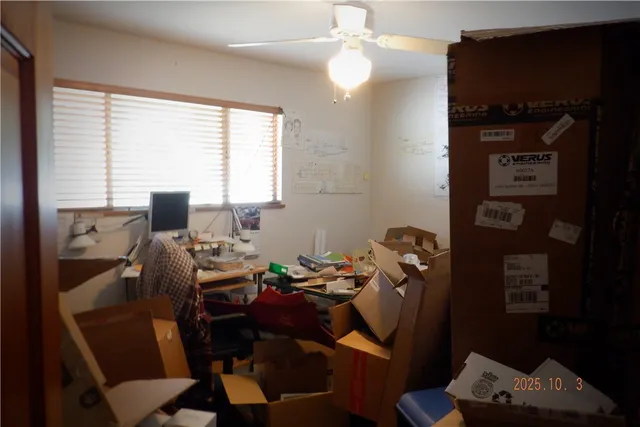 a view of a workspace with furniture and a window