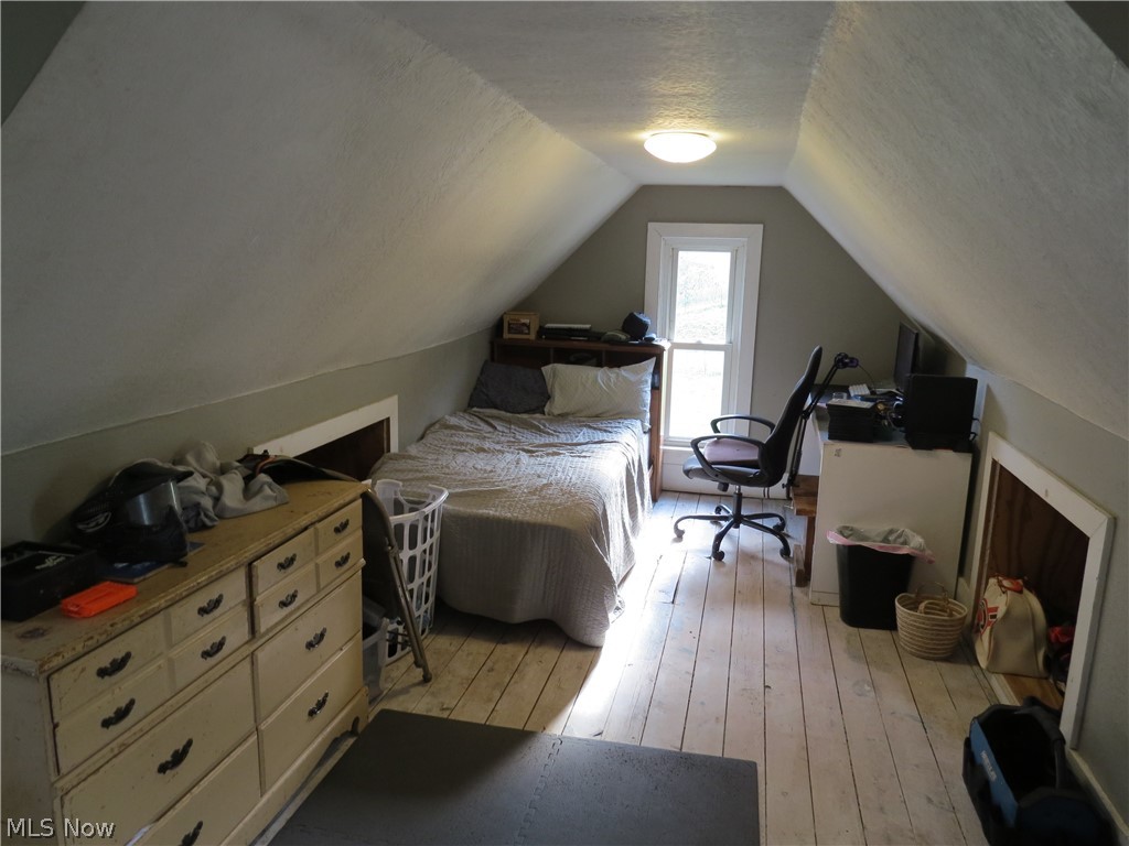 2205 Irish Road Magnolia, OH 44643 - Photo 19 of 31 Bedroom featuring vaulted ceiling, a textured ceiling, and light wood-type flooring
