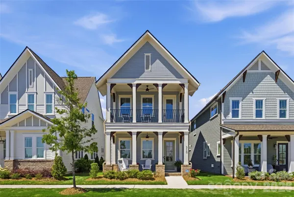 a front view of a residential apartment building with yard and green space