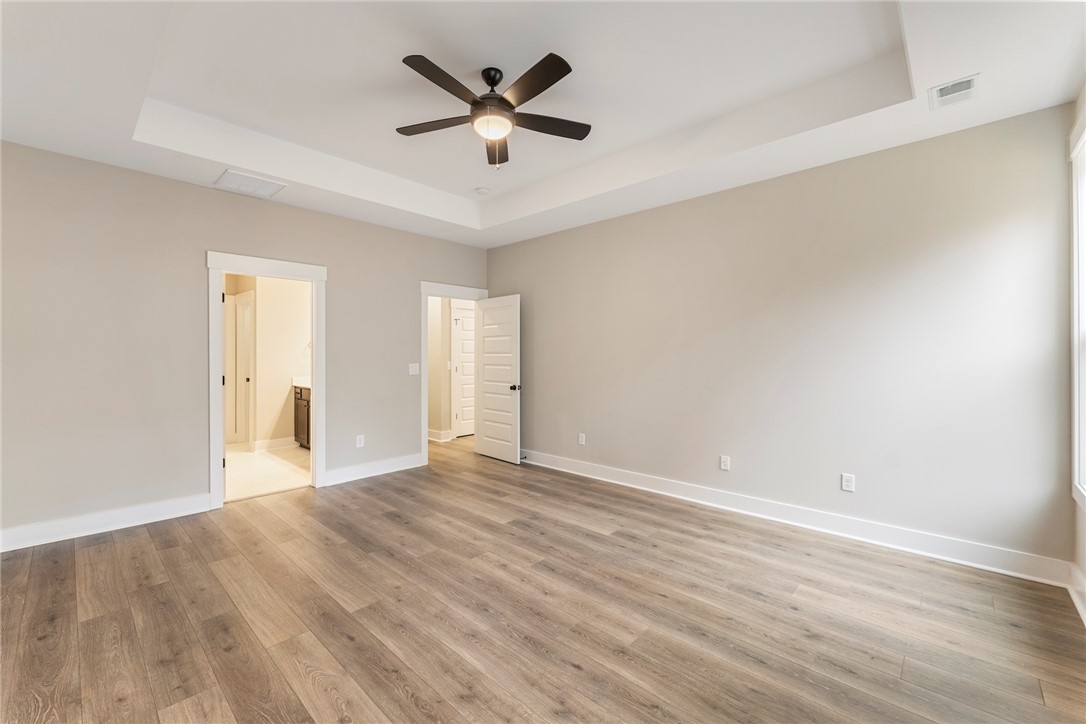 121 Falcon Crest Way Pickens, SC 29671 - Photo 10 of 13 This spacious bedroom features elegant flooring and a ceiling fan, creating a comfortable living space.