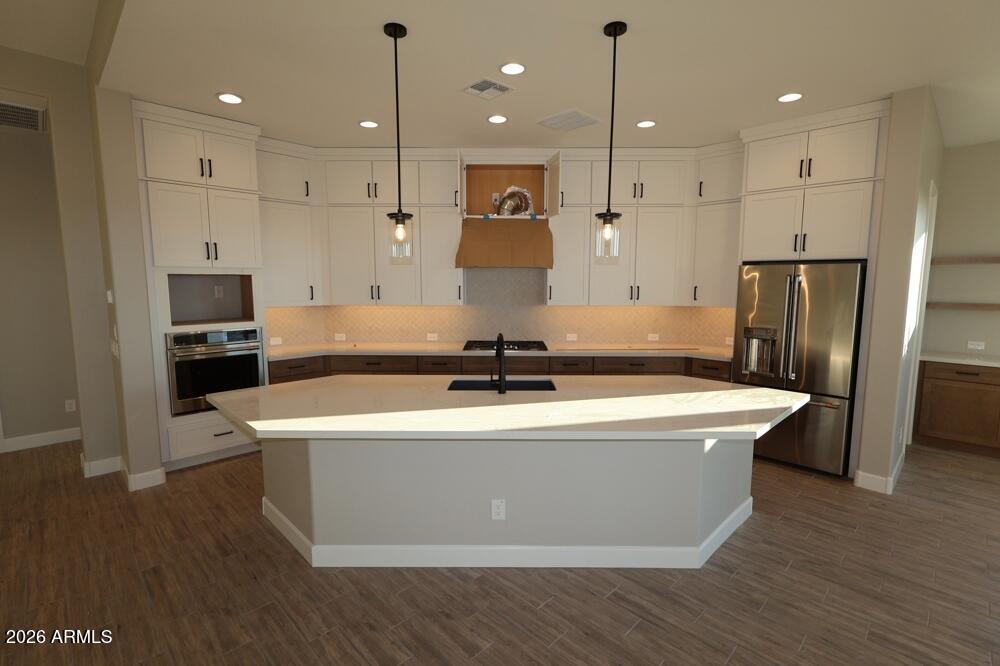 18921 West Lawrence Road Waddell, AZ 85355 - Photo 2 of 9 a view of a kitchen with kitchen island a sink stainless steel appliances and cabinets