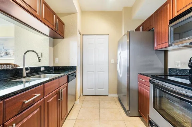 a kitchen with stainless steel appliances granite countertop a refrigerator and a stove top oven