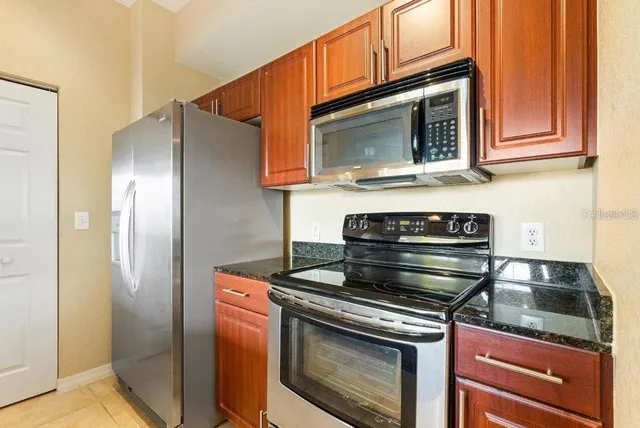 a kitchen with stainless steel appliances granite countertop a stove microwave and cabinets
