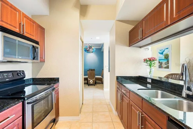a kitchen with granite countertop a sink and a stove top oven