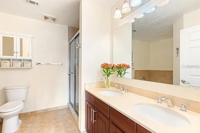 a bathroom with a granite countertop sink toilet and shower
