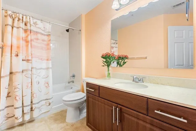 a bathroom with a sink a toilet and a large mirror