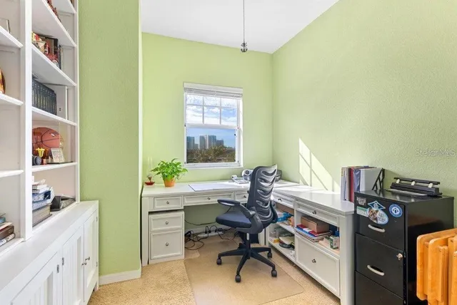 a view of a workspace with furniture and a window