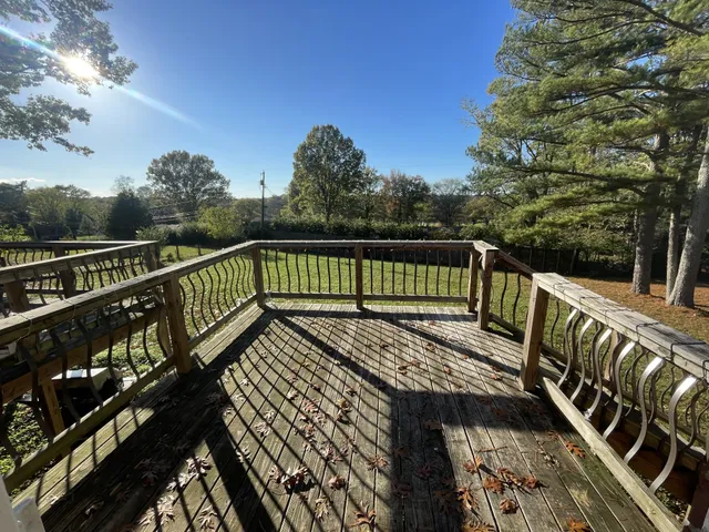 a view of balcony with wooden floor and fence
