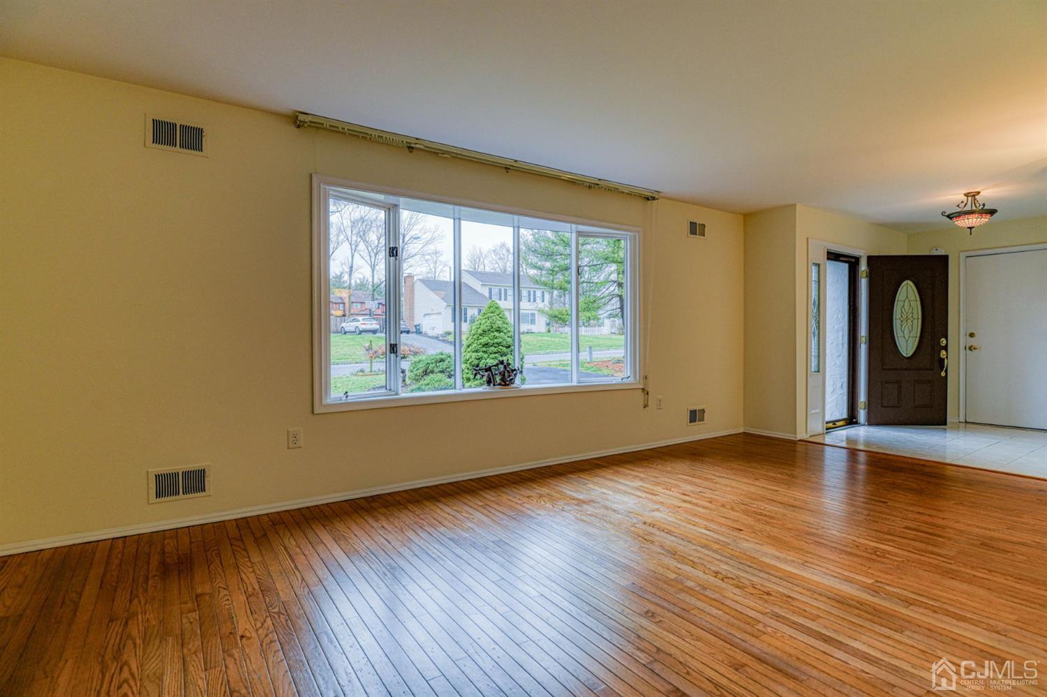 43 Pinecrest Road Somerset, NJ 08873 - Photo 6 of 34 a view of an empty room with wooden floor and a window