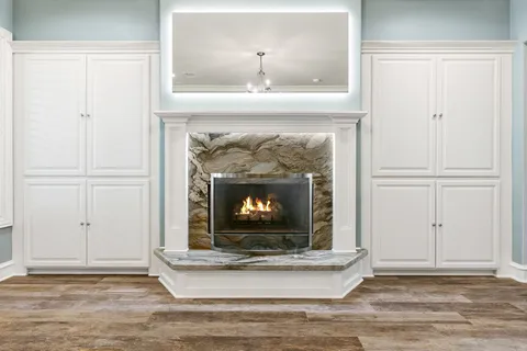 a kitchen with granite countertop kitchen island wooden floor center island stainless steel appliances and cabinets