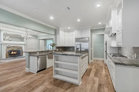 a kitchen with stainless steel appliances granite countertop a sink a counter space and cabinets