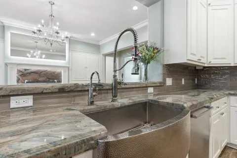 a kitchen with granite countertop a sink and cabinets