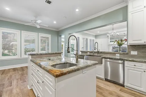 a kitchen with granite countertop a sink stove and cabinets