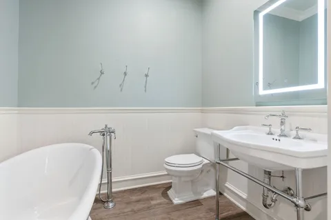 a bathroom with a sink a toilet and a mirror