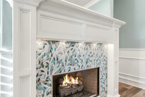a living room with furniture chandelier and a fireplace