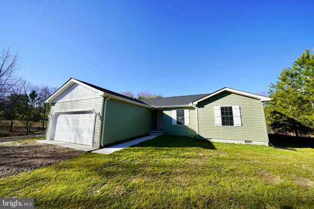 a white house with a big yard and large trees