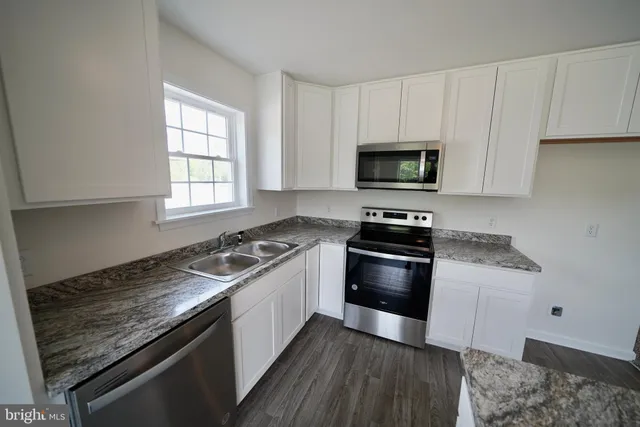 a kitchen with granite countertop a stove and a sink