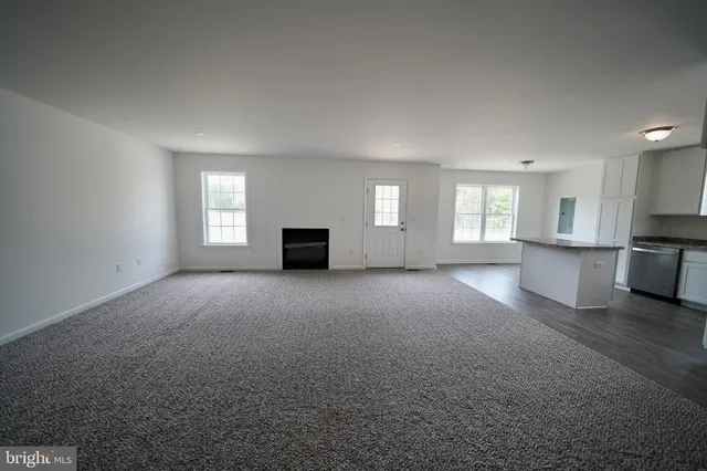 a view of empty room with a fireplace and window