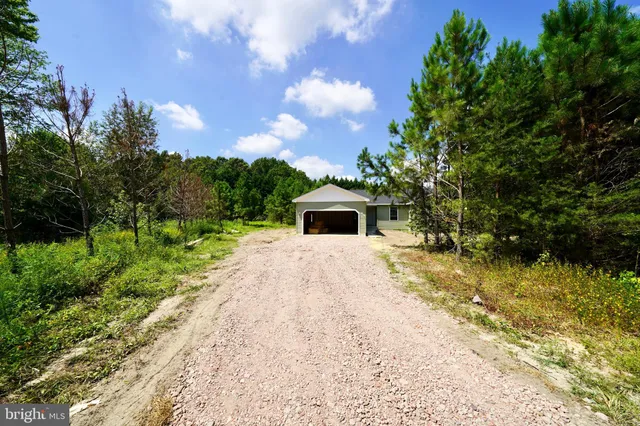 a white house with a yard and a large tree