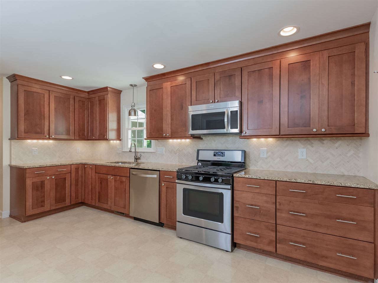 5713 Edgedale Drive Raleigh, NC 27612 - Photo 14 of 30 Remodeled with exquisite cabinets, granite counters, under counter LED lighting, herringbone design marble backsplash, recessed lighting, stainless steel appliances, and 5 burner gas range with convection oven. Kitchen