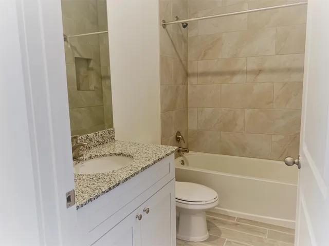 a bathroom with a granite countertop sink toilet and shower