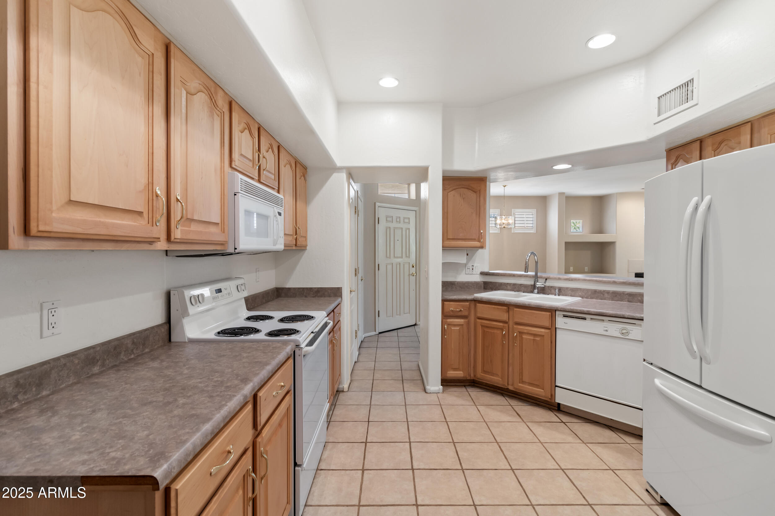 1747 East Northern Avenue, Unit 104 Phoenix, AZ 85020 - Photo 3 of 19 a kitchen with stainless steel appliances granite countertop a refrigerator a stove and a sink
