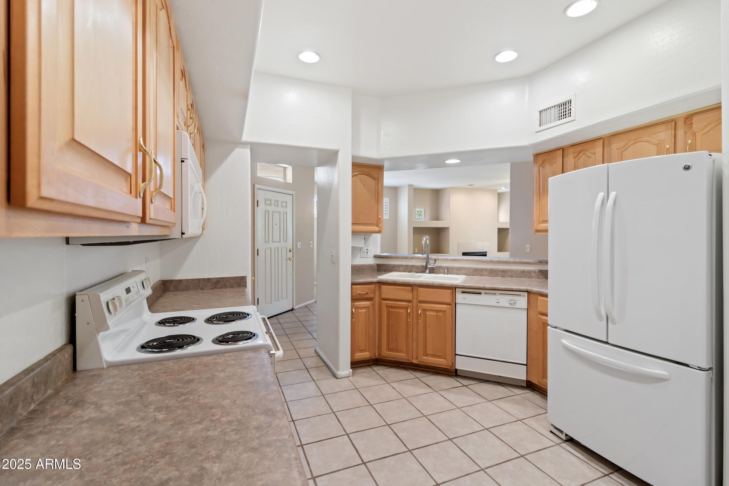 1747 East Northern Avenue, Unit 104 Phoenix, AZ 85020 - Photo 7 of 19 a kitchen with stainless steel appliances granite countertop a refrigerator sink and stove