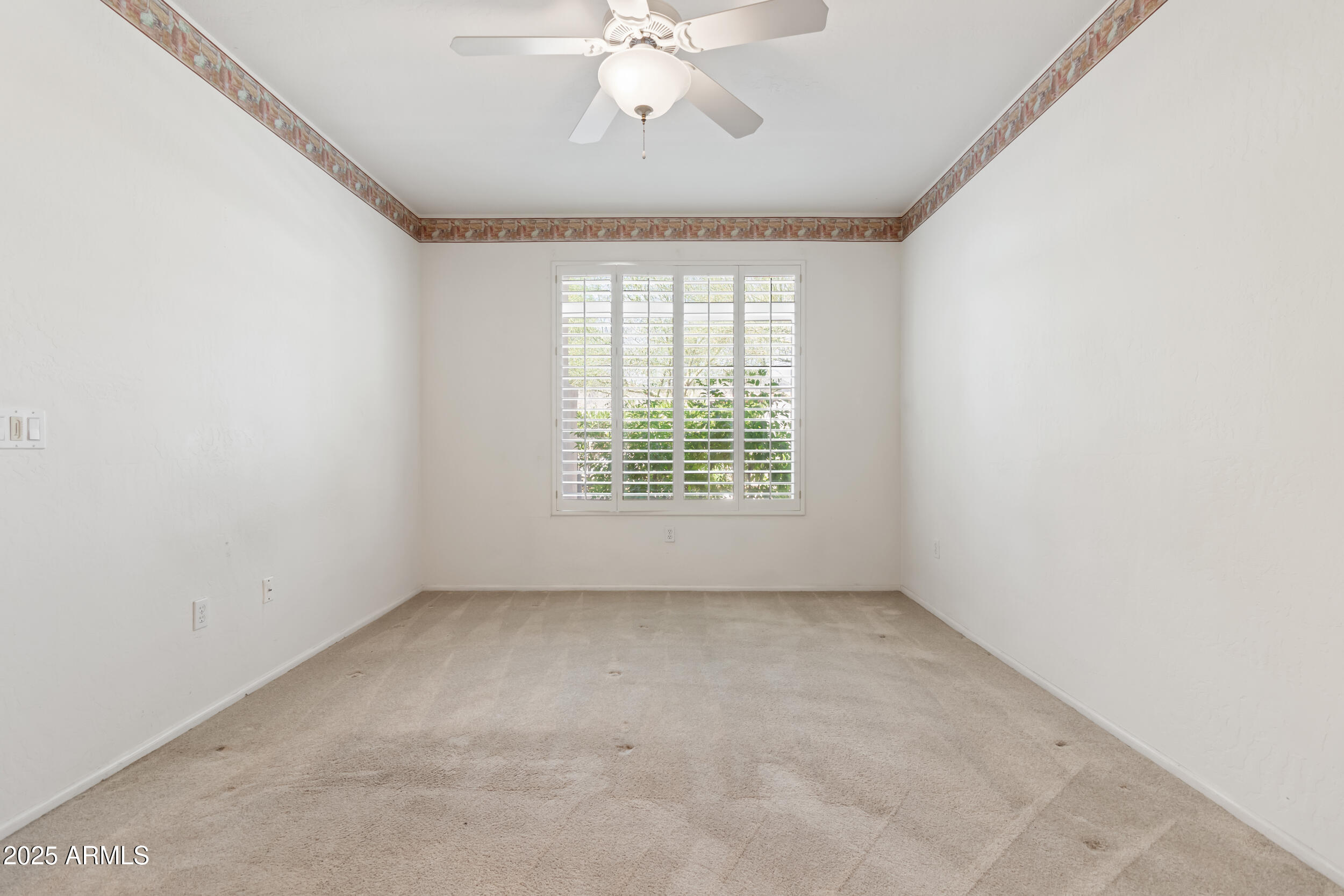 1747 East Northern Avenue, Unit 104 Phoenix, AZ 85020 - Photo 10 of 19 an empty room with windows and chandelier fan