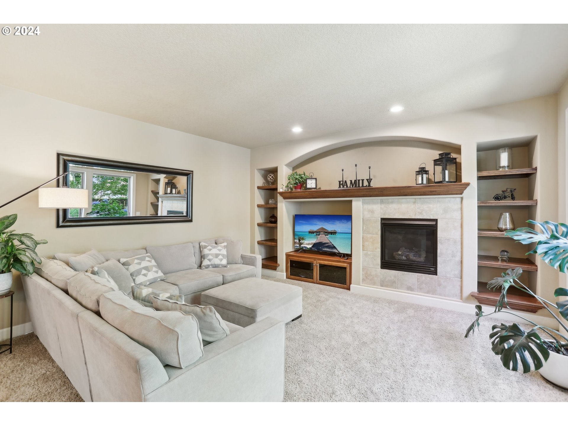 7885 Southwest Daybreak Street Wilsonville, OR 97070 - Photo 18 of 48 a living room with furniture a fireplace and a flat screen tv