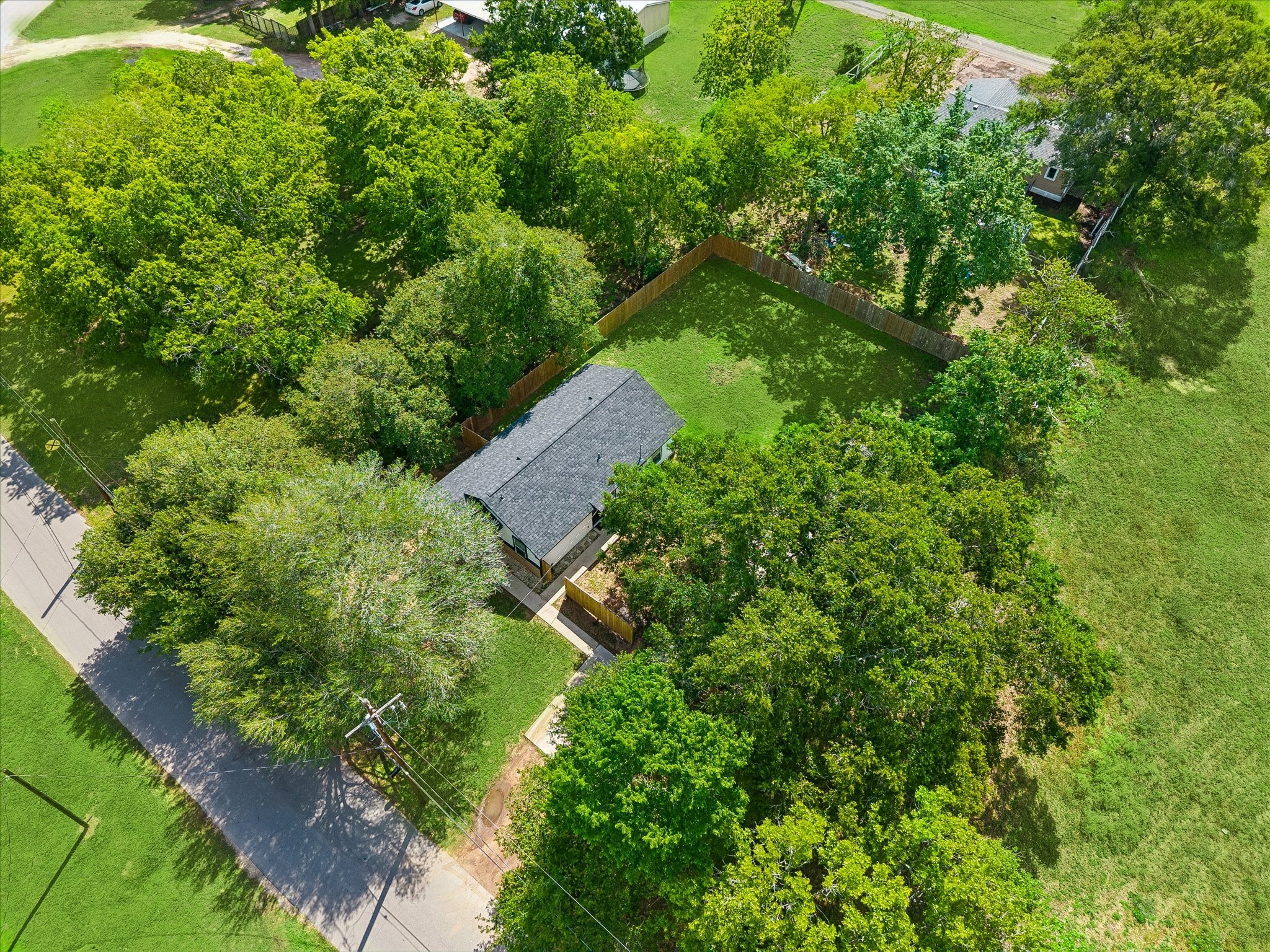 539 Anderson Street Sealy, TX 77474 - Photo 19 of 19 Single-story home nestled among lush greenery, featuring a spacious fenced yard for privacy. Ideal corner lot location with ample outdoor space and mature trees.