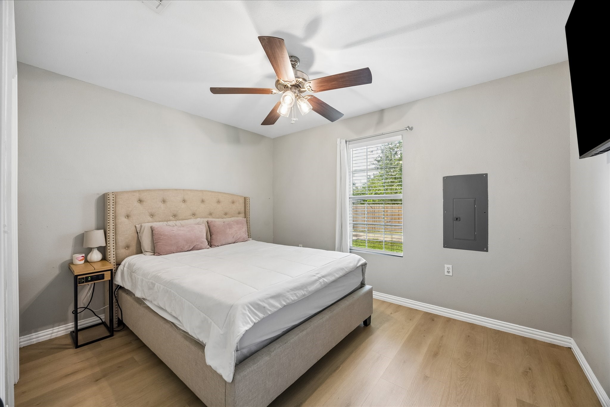 539 Anderson Street Sealy, TX 77474 - Photo 4 of 19 Bright and cozy bedroom with neutral walls, and wood flooring. Features a ceiling fan and a window for natural light.