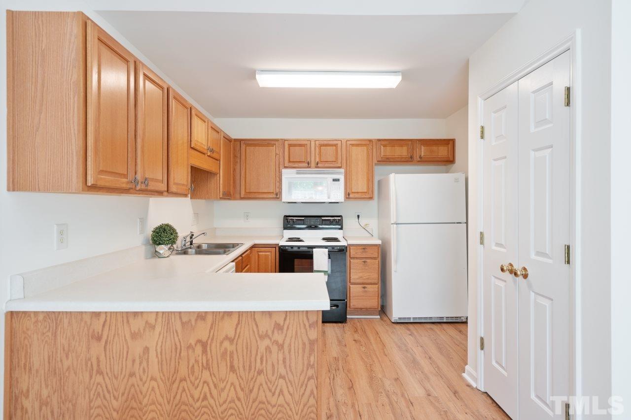 616 Rookwood Court Wake Forest, NC 27587 - Photo 13 of 30 a kitchen with granite countertop a refrigerator a sink dishwasher and a stove with wooden floor