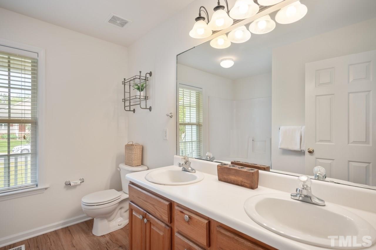 616 Rookwood Court Wake Forest, NC 27587 - Photo 30 of 30 a bathroom with a toilet a sink a large mirror and a window