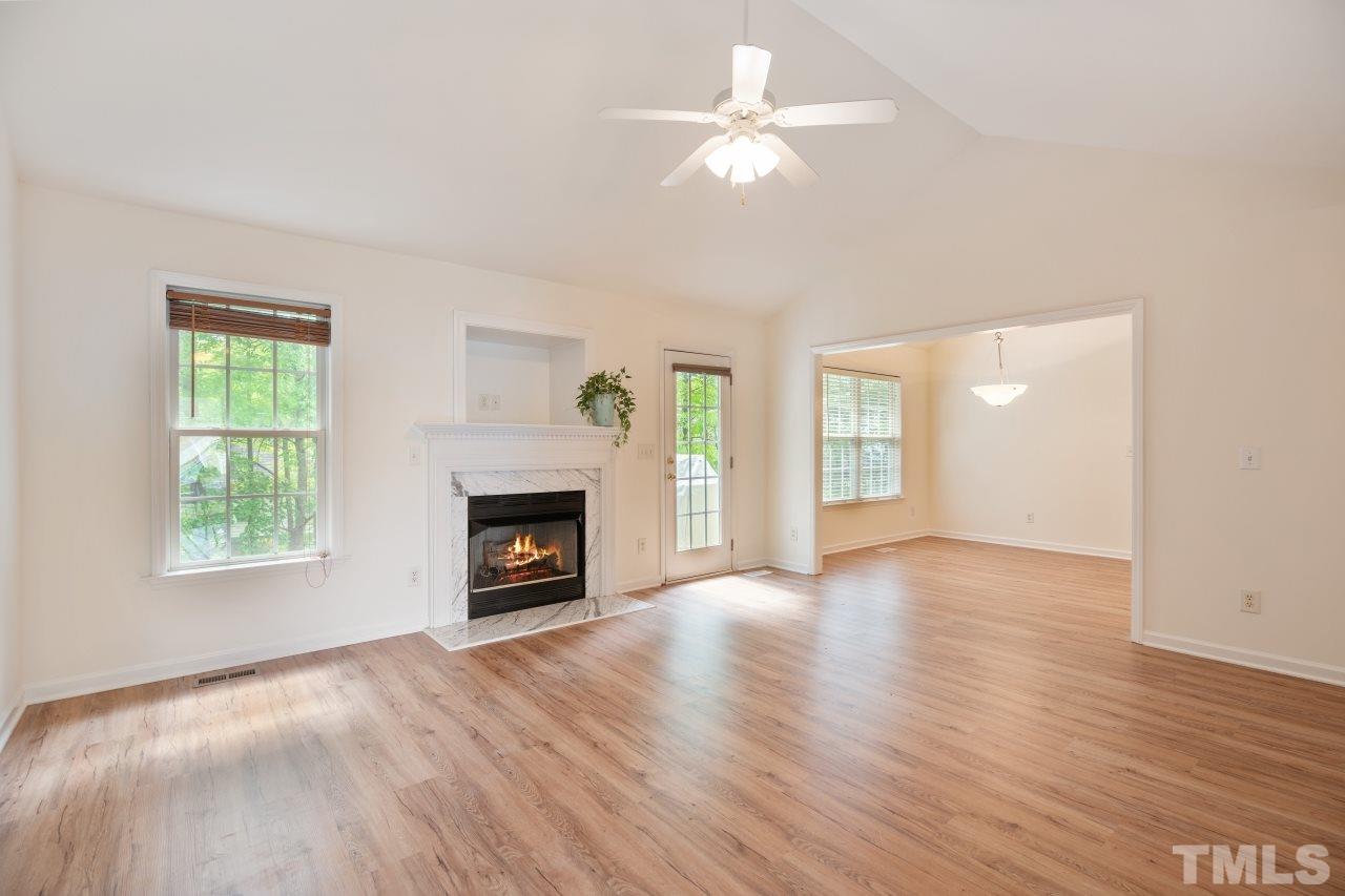 616 Rookwood Court Wake Forest, NC 27587 - Photo 10 of 30 an empty room with windows a fireplace and wooden floor