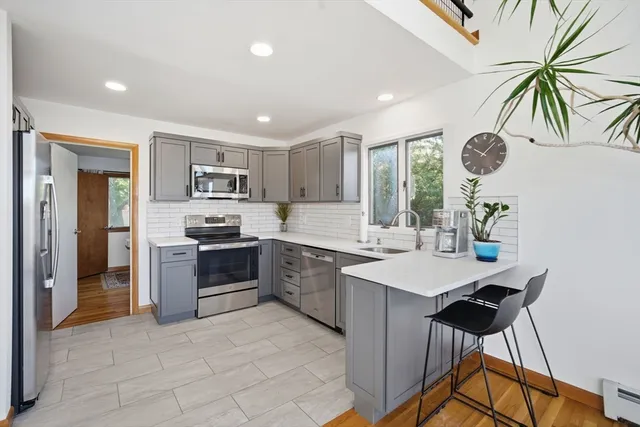 a kitchen with a sink a stove cabinets and stainless steel appliances