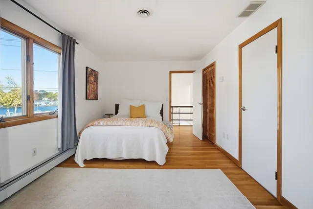 a bedroom with a bed and a large window