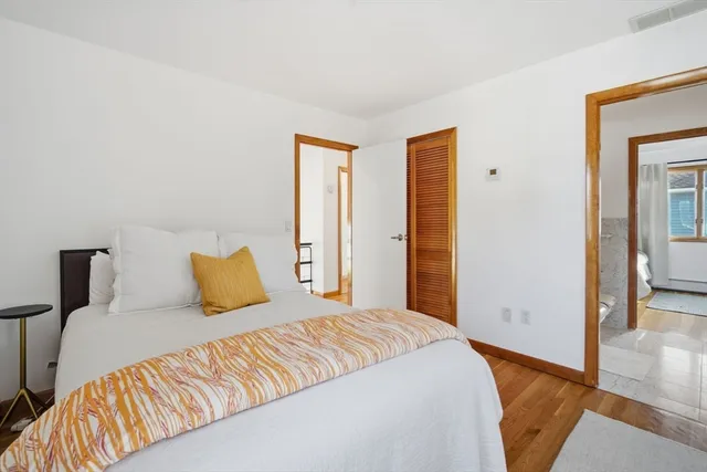 a bedroom with a bed and wooden floor