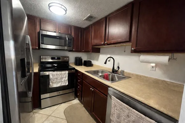 a kitchen with stainless steel appliances a sink a stove cabinets and a refrigerator