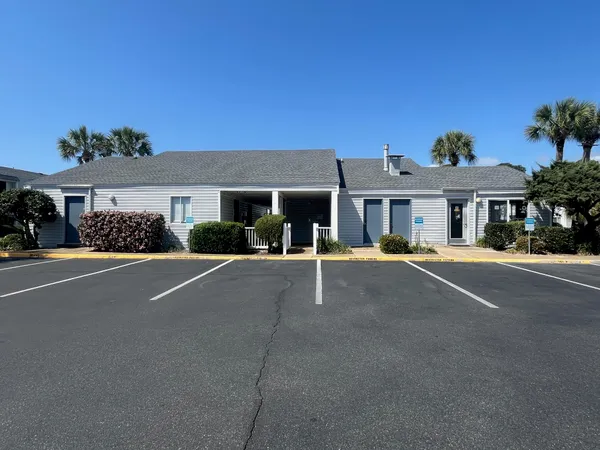 a view of a house with a small yard and wooden fence