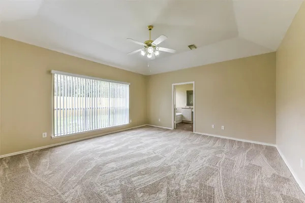 an empty room with wooden floor and ceiling fan