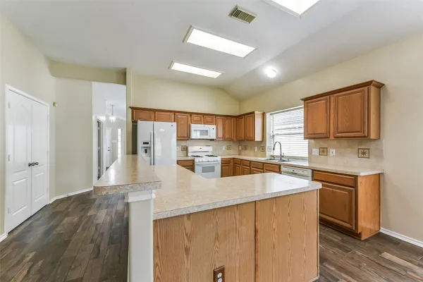 a kitchen with a sink a stove a refrigerator and cabinets