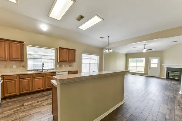 a large kitchen with stainless steel appliances lots of counter space and wooden floor