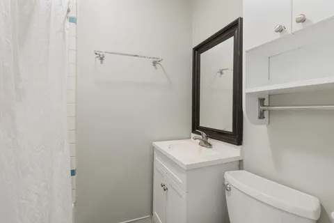 a bathroom with a toilet sink and mirror