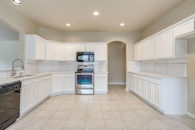 a kitchen with a sink a stove and cabinets