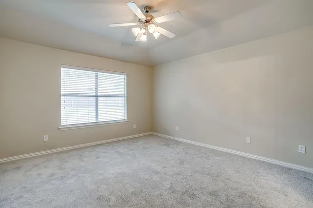 an empty room with closet and a ceiling fan
