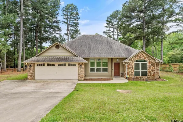 a front view of a house with a yard and trees