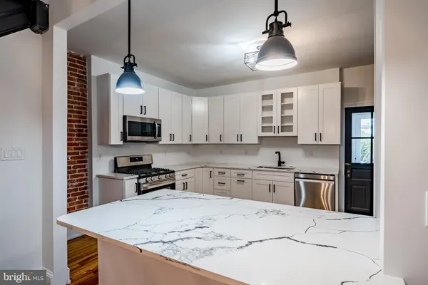 a kitchen with a sink a stove and microwave