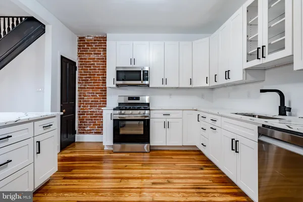 a kitchen with stainless steel appliances a stove sink microwave and cabinets